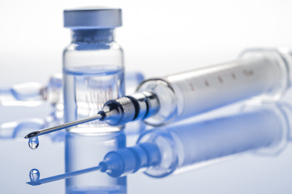 syringe and clear liquid filled vial