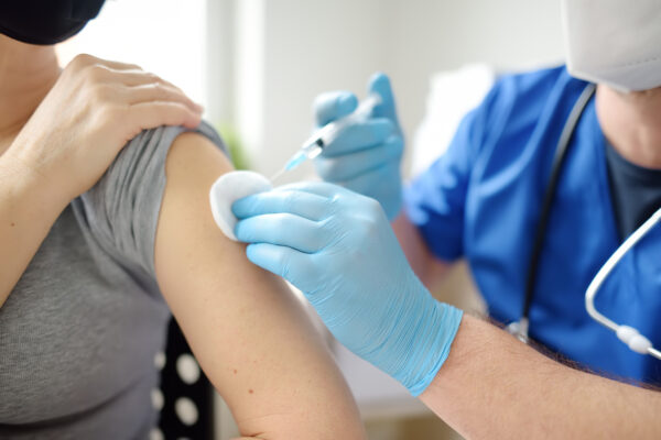 A photo of a doctor injecting a patient